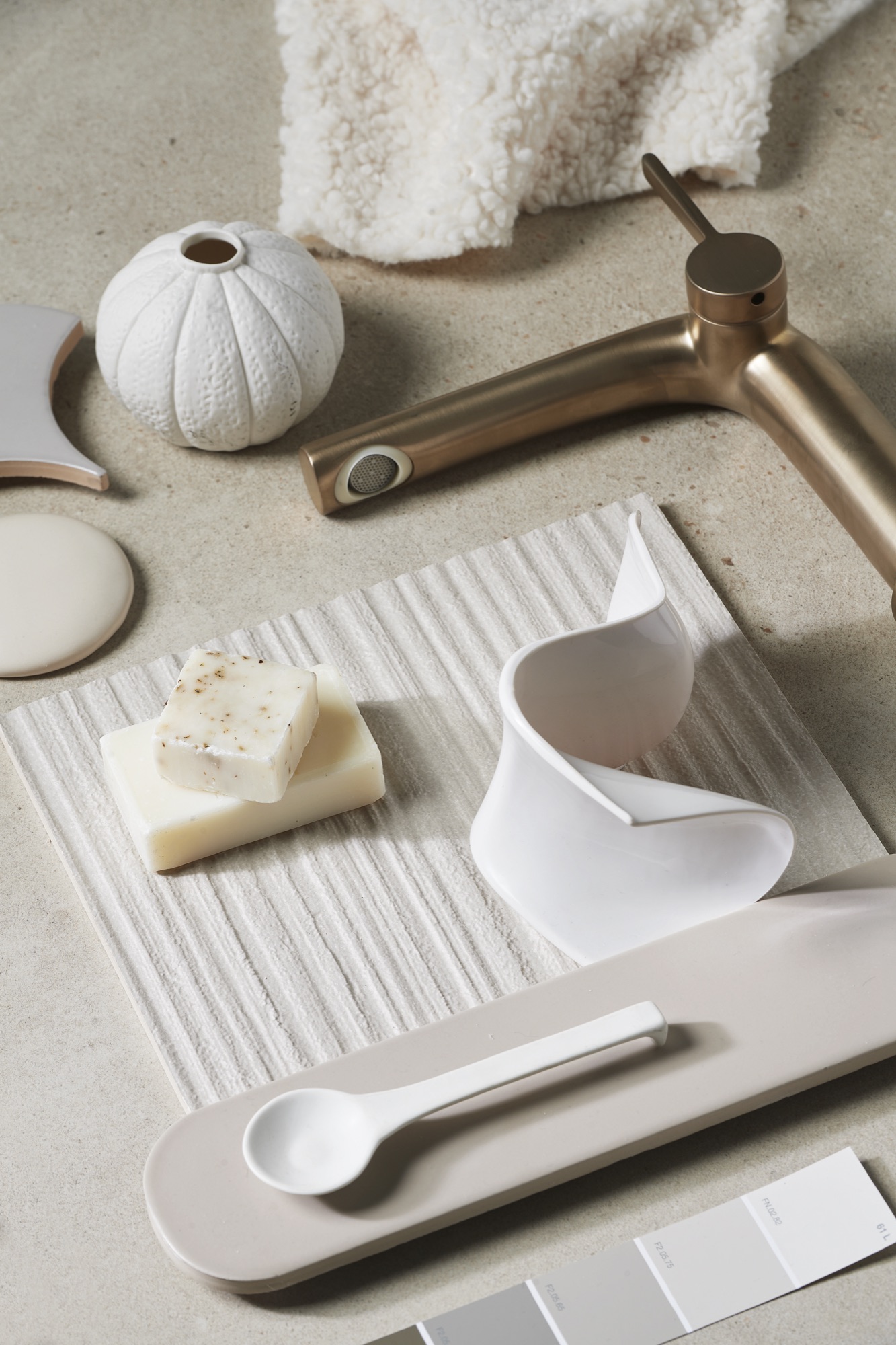 Bronzen wastafelkraan op een beige moodboard