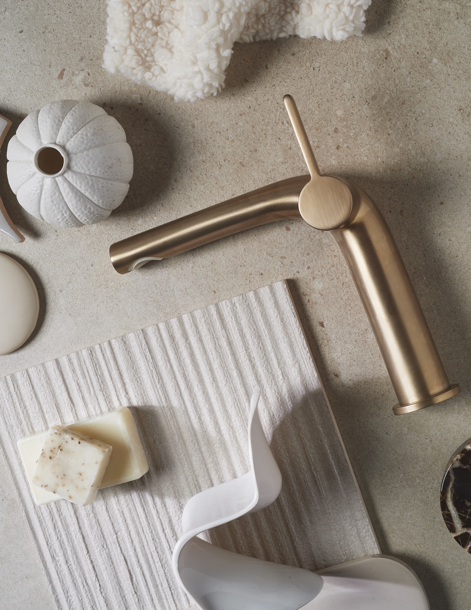 Messing wastafelkraan op een beige moodboard